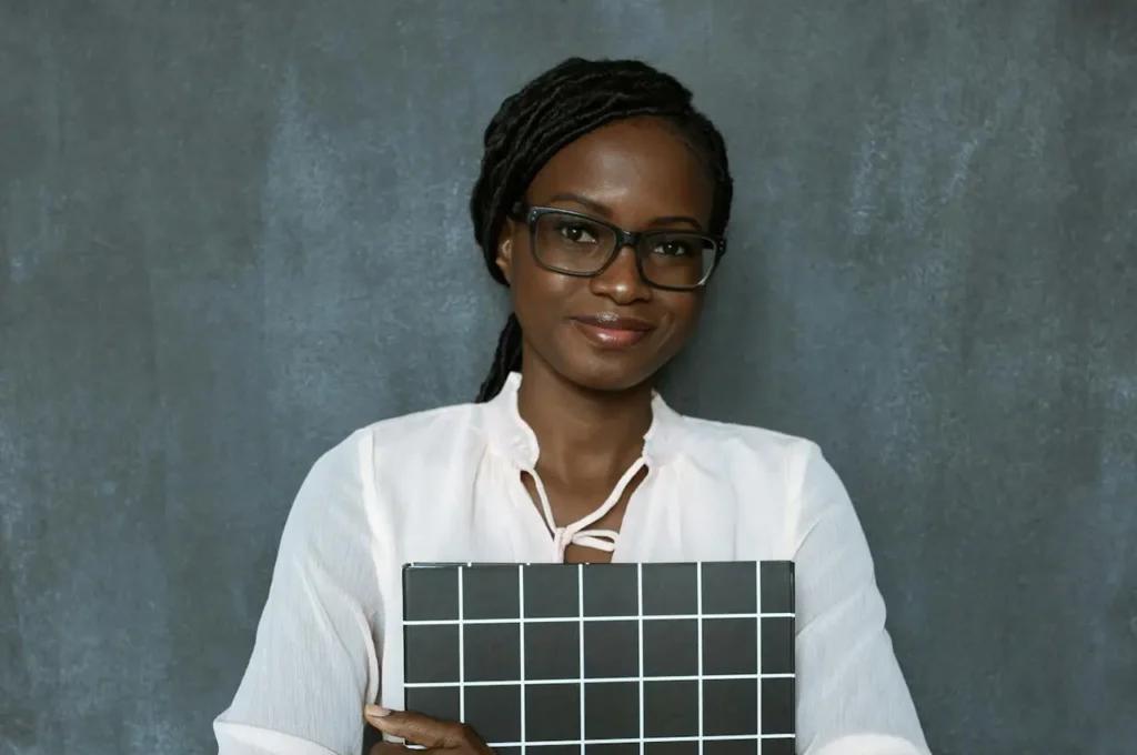 Professional woman standing with a grid board against a textured background.